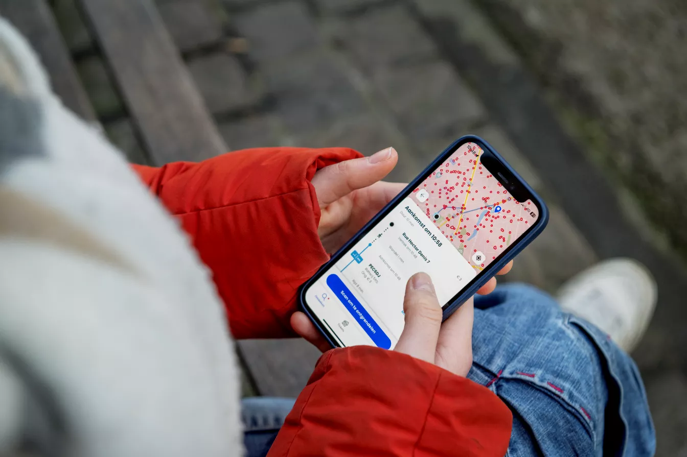 Persoon die haar telefoon houdt met de Floya-app open