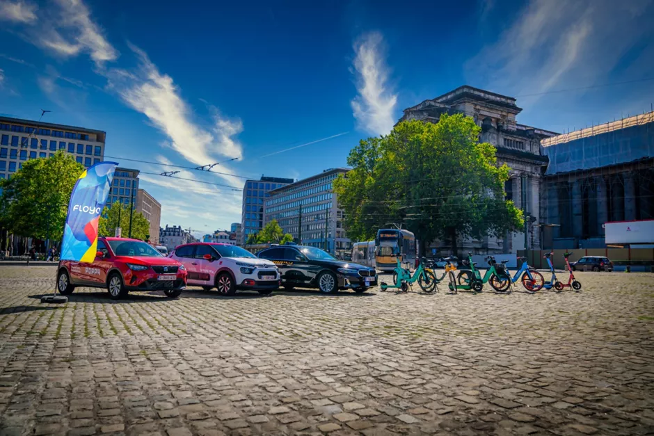 Tram passing behind cars, taxis, bikes and scooters from the mobility brands available in Floya